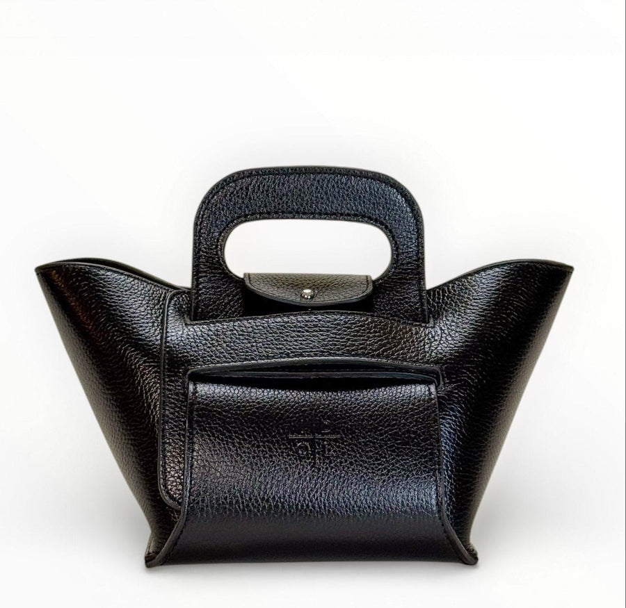 Front view of a black collapsible handbag with pebbled finish, cutout handle, and embossed logo stamp.”