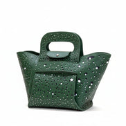 Green handbag with decorative studs on a light gray background